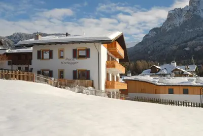 a building on top of a snow covered hill at Garni Karlegger in Siusi