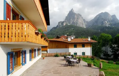 a patio with a table and chairs in front of a house at Garni Karlegger in Siusi
