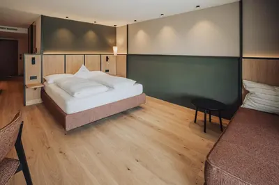 a bedroom with a bed and a table in it at Hotel Lisetta in Tirolo