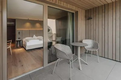 a bedroom with a bed and a table and chairs at Hotel Lisetta in Tirolo