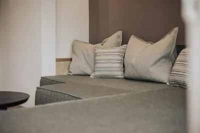 a couch with several pillows on top of it at Hotel Lisetta in Tirolo