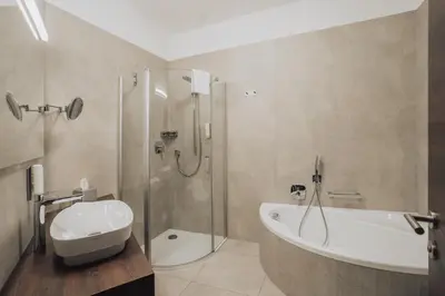 a bathroom with a shower and a toilet and a sink at Hotel Lisetta in Tirolo