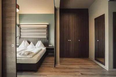 a bedroom with a bed and a mirror at Hotel Lisetta in Tirolo
