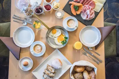 a table with breakfast foods and drinks on it at Apparthotel Feldhof - Living and Bistro in Nova Ponente