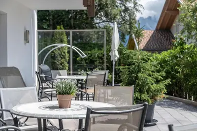 a table and chairs on a patio with a table at Apparthotel Feldhof - Living and Bistro in Nova Ponente