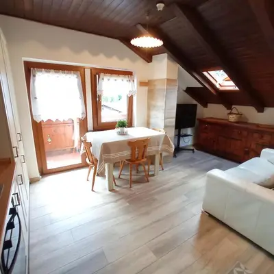 a living room with a table and a couch at La Mansarda di Sabina. in Fiera di Primiero