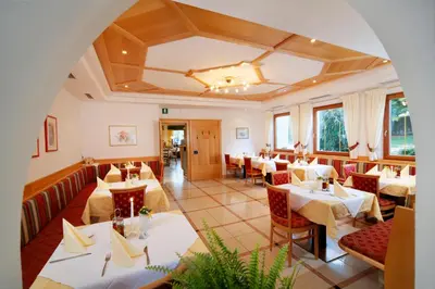 a restaurant with tables and chairs in a room at Hotel Unterrain in Appiano sulla Strada del Vino