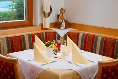 a table with a white table cloth on it at Hotel Unterrain in Appiano sulla Strada del Vino