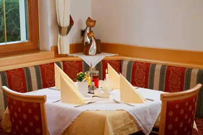 a table with two chairs and a teddy bear on top at Hotel Unterrain in Appiano sulla Strada del Vino