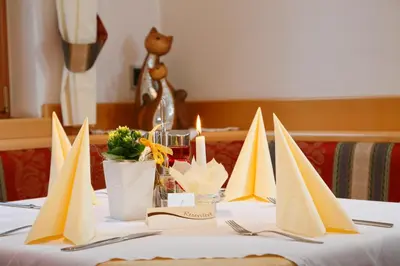 a table with yellow and white paper napkins on it at Hotel Unterrain in Appiano sulla Strada del Vino