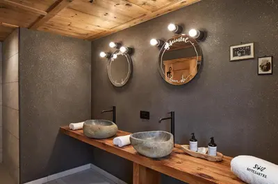 a bathroom with two sinks on a wooden counter at Sotciastel Antico Chalet in Badia