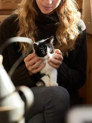 a woman is holding a black and white cat at Sotciastel Antico Chalet in Badia