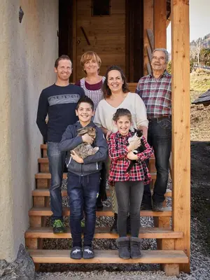 a family standing on the stairs of a cabin at Sotciastel Antico Chalet in Badia