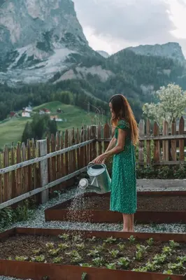 a girl in a green dress drinking water from a fountain at Sotciastel Antico Chalet in Badia