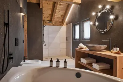 a bathroom with a bath tub and a sink at Sotciastel Antico Chalet in Badia