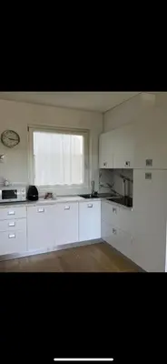 an empty kitchen with white cabinets and a window at Azalea in Cornaiano