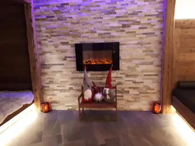 two gnomes sitting in a chair in front of a fireplace at Radauerhof in Castelrotto