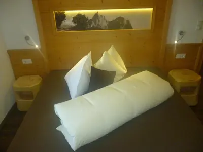 a bed with white pillows in a room at Radauerhof in Castelrotto