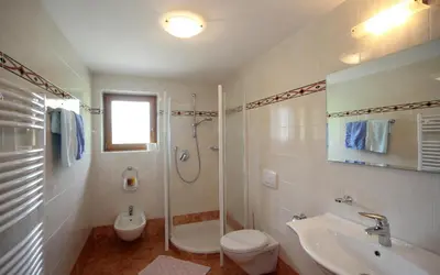 a bathroom with a toilet and a shower and a sink at Garni Miriam in La Villa
