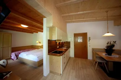 a bedroom with a bed and a desk and a table at Garni Miriam in La Villa