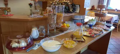 a counter with many different types of food on it at Garni Miriam in La Villa