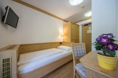 a bedroom with a bed and a table with a plant at Garni Miriam in La Villa