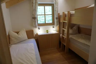 a small room with two bunk beds and a window at Niederhaushof in Santa Valburga St. Walburg