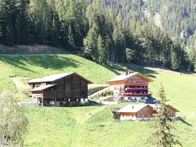 a couple of buildings on a green hill with trees at Niederhaushof in Santa Valburga St. Walburg