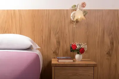 a bedroom with a bed and a vase of flowers on a table at Hotel Centrale in Alleghe