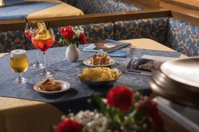 a table with plates of food and glasses of wine at Hotel Centrale in Alleghe