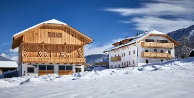 a house and a building in the snow at Huberhof in San Lorenzo di Sebato
