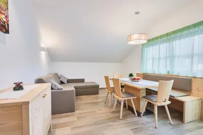 a living room with a table and a couch at Huberhof in San Lorenzo di Sebato