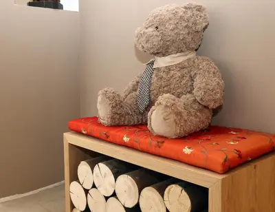 a teddy bear sitting on top of a bench at Appartamenti Te Paisc in La Villa