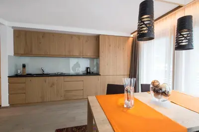a dining room with a table and a kitchen at Appartamenti Te Paisc in La Villa