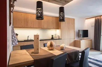 a dining room with a table and a kitchen at Appartamenti Te Paisc in La Villa