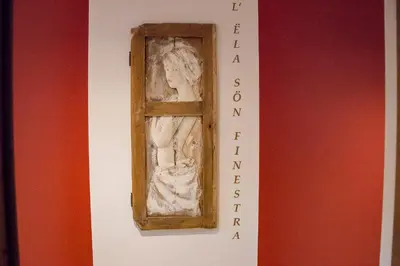 a statue of a woman in a window on a wall at Appartamenti Te Paisc in La Villa