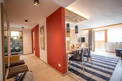 a dining room and living room with a table and chairs at Appartamenti Te Paisc in La Villa