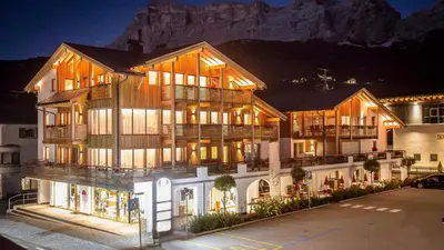 a large building with a mountain in the background at Appartamenti Te Paisc in La Villa