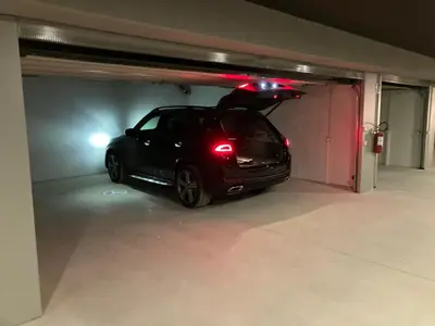 a car parked in a garage with its lights on at Florisa Mountain Penthouse in San Vigilio Di Marebbe