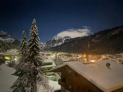 a view of a town in the snow at night at Florisa Mountain Penthouse in San Vigilio Di Marebbe