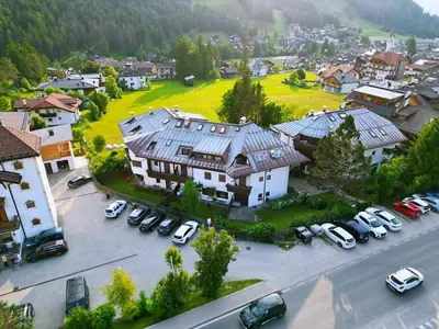 an aerial view of a town with cars parked in a parking lot at Les Corcelles in San Vigilio Di Marebbe