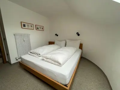 a bed with white sheets and pillows in a room at Les Corcelles in San Vigilio Di Marebbe