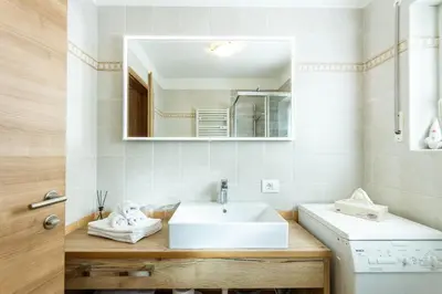 a bathroom with a white sink and a mirror at Apartment Sabrina in Santa Cristina in Val Gardena