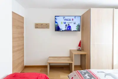 a bedroom with a bed and a tv on the wall at Apartment Sabrina in Santa Cristina in Val Gardena
