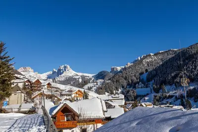a village covered in snow with mountains in the background at Apartment Sabrina in Santa Cristina in Val Gardena