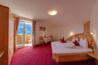 a hotel room with two beds and a balcony at Appartements Verdinserhöhe in Schenna