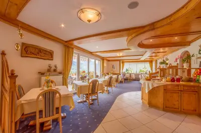 a restaurant with tables and chairs in a room at Appartements Verdinserhöhe in Schenna