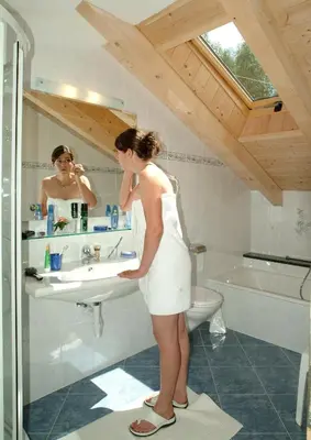 a woman standing in front of a sink in a bathroom at Appartements Verdinserhöhe in Schenna