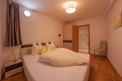 a bedroom with a large white bed with yellow pillows at Appartements Verdinserhöhe in Schenna