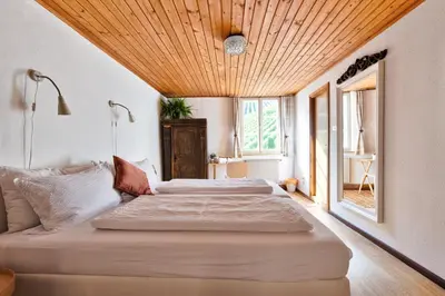 a bedroom with a large bed with a wooden ceiling at Privatzimmervermietung Messner in Rifiano
